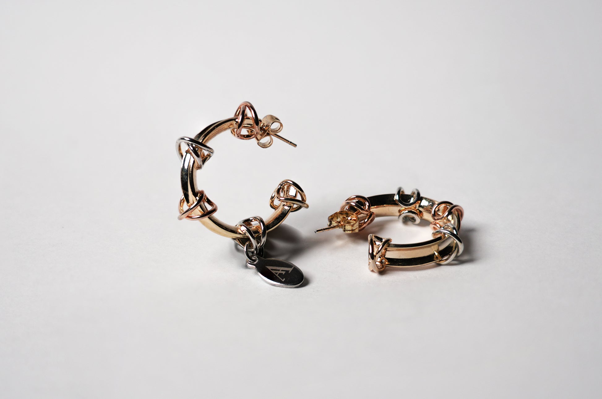 Aretes trinity de plata y gold-filled estilo argolla con detalles entrelazados de AMARYLLIS ANGLE
